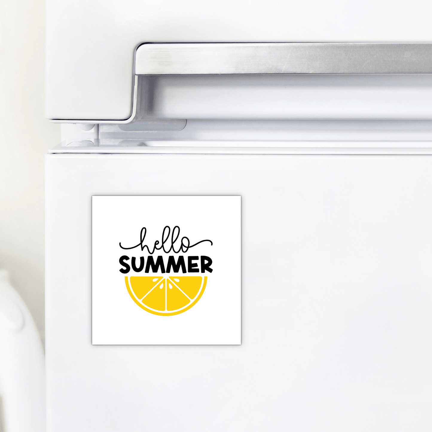 A white fridge displays the Mirabilia Boutique "Hello Summer Lemon Magnet – Bold Citrus Fridge Art," featuring a yellow lemon slice and "hello SUMMER" in playful black font—ideal for adding summer cheer to your kitchen.