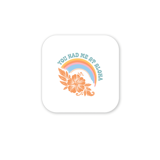 The "You Had Me at Aloha Magnet – Tropical Rainbow & Hibiscus" from Mirabilia Boutique features a pastel rainbow, orange hibiscus, and blue text—a charming fridge or beach house decor accent.