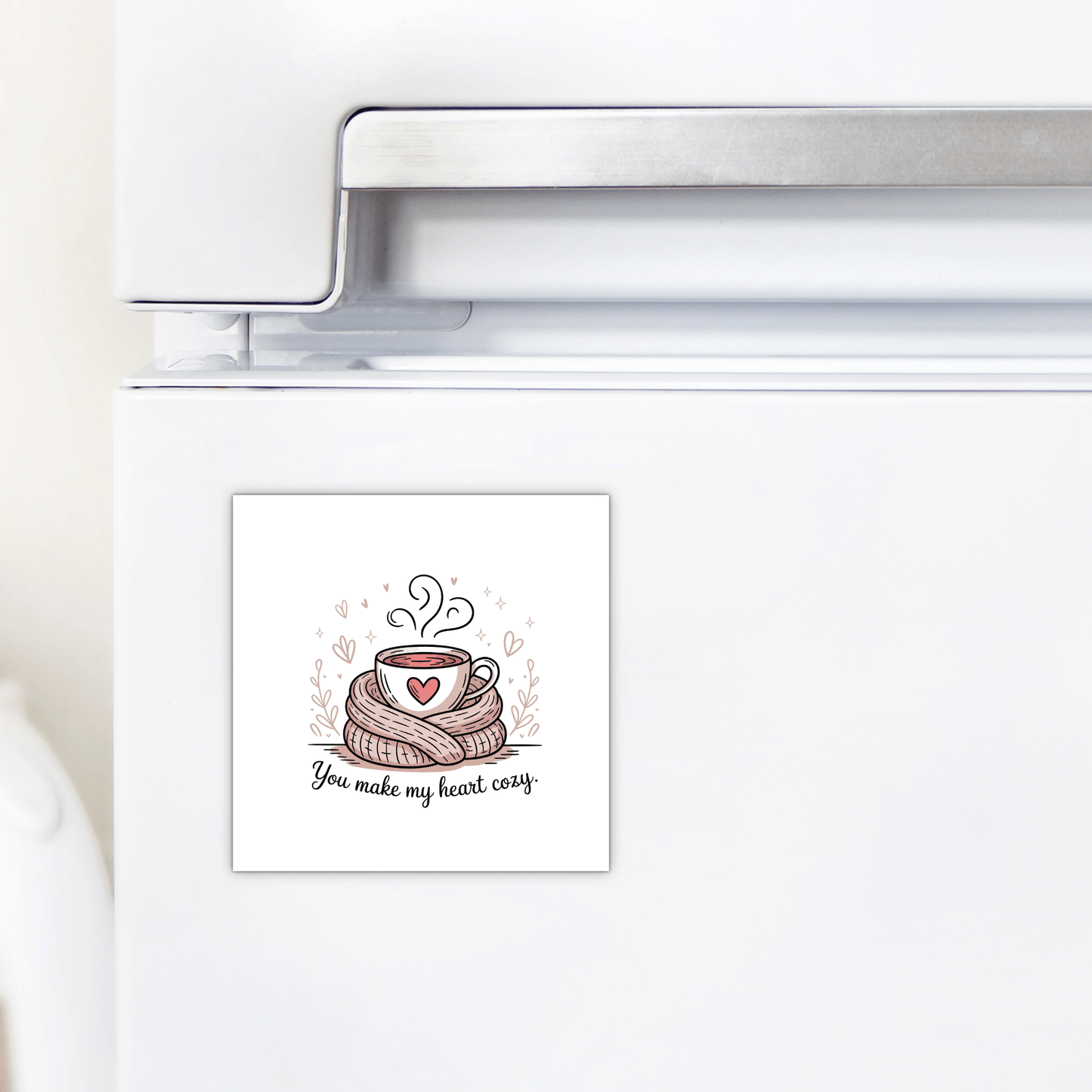 The Cozy Heart Magnet by Mirabilia Boutique features a steaming cup and heart in a knitted scarf with the message "You Make My Heart Cozy," making it a charming romantic gift or a perfect treat for any cocoa lover.