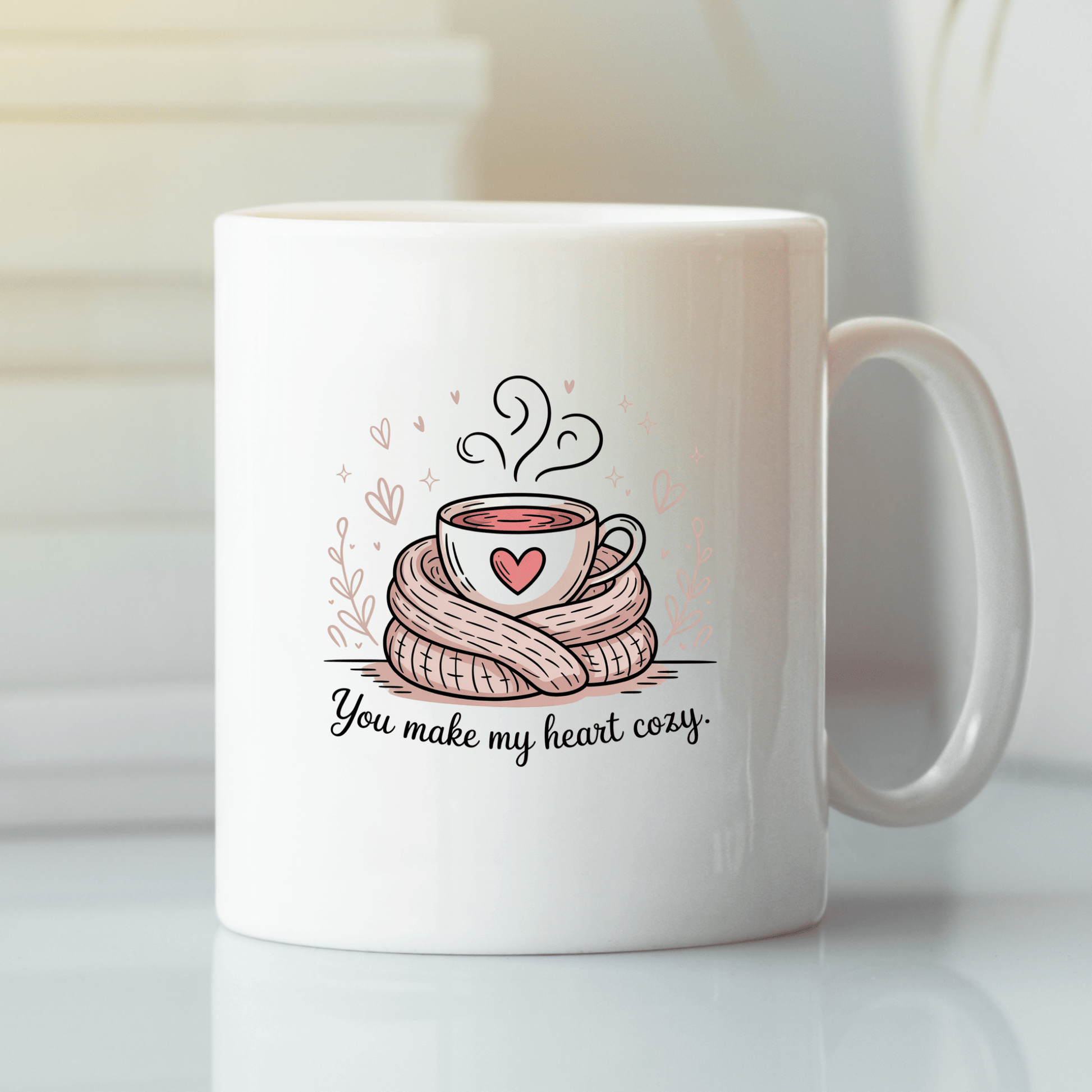 The "You Make My Heart Cozy Mug" by Mirabilia Boutique features a white mug with a steaming cup wrapped in a scarf and pink hearts, plus "You make my heart cozy" text—a cute Valentine’s Day gift for coffee lovers.