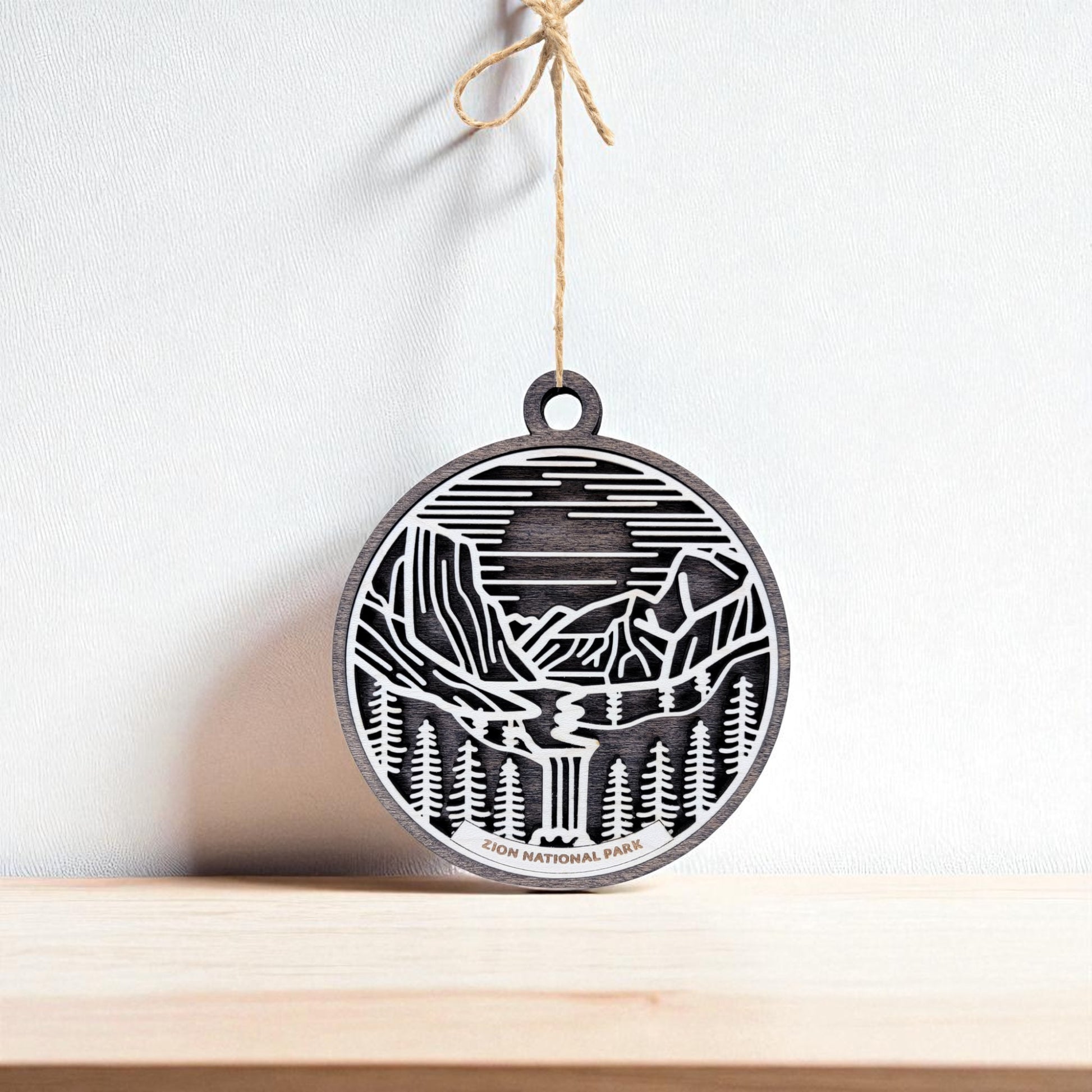 The Zion National Park Ornament by Mirabilia Boutique is a handcrafted wooden keepsake with a black and white cutout of the park’s mountains, trees, and river. It hangs on a string and makes an ideal National Park gift.
